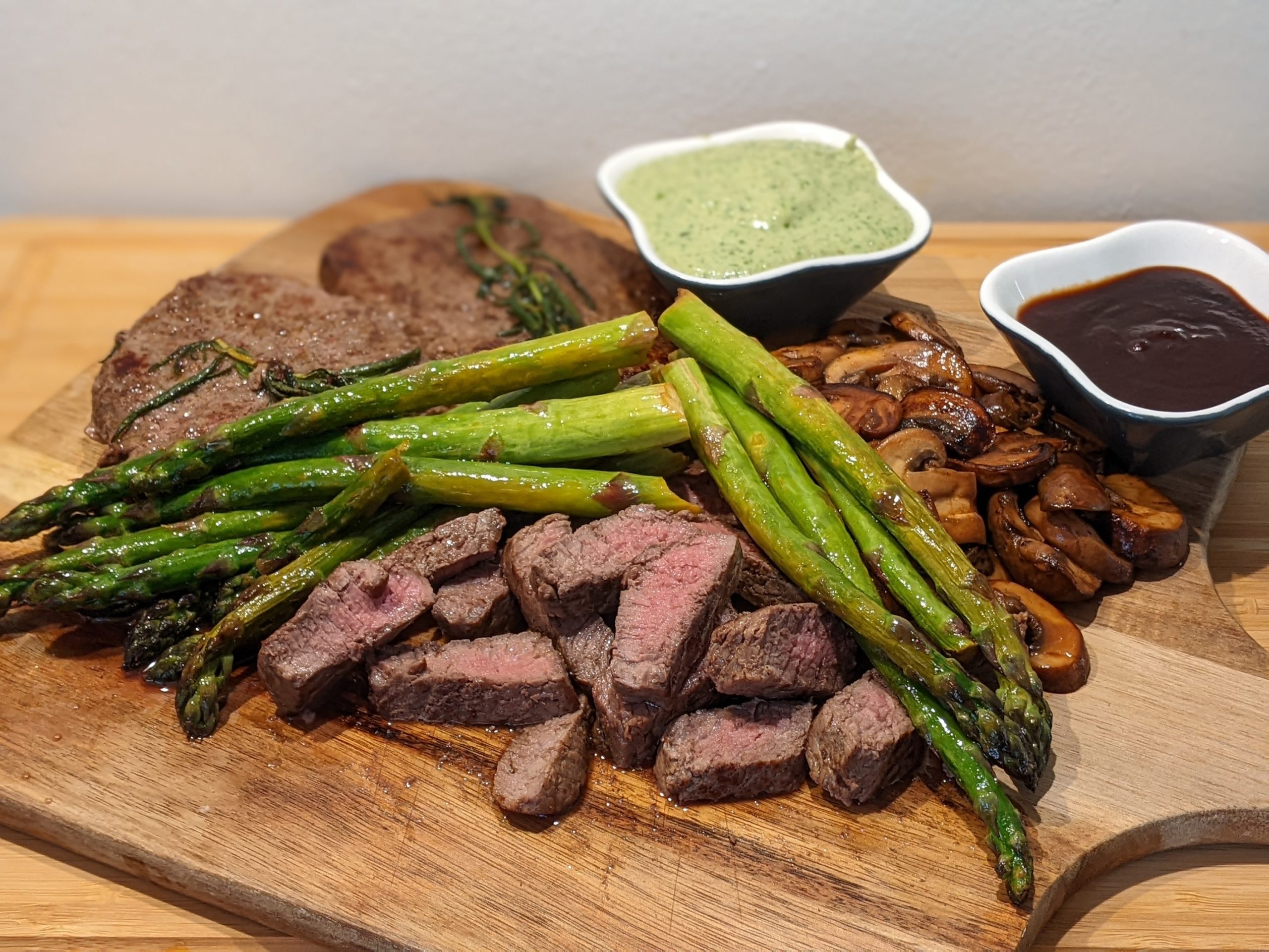 Steak Delight: A Sizzling Platter with Crispy Fried Mushrooms, Asparagus and Homemade Pesto